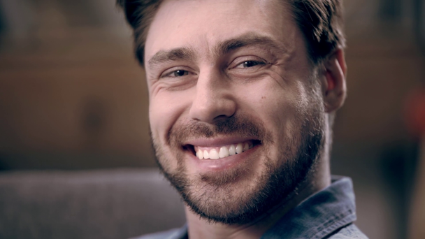 glücklicher Mann mit Bart, der lacht und blinzelt, während er in die Kamera schaut - Filmmaterial, Video