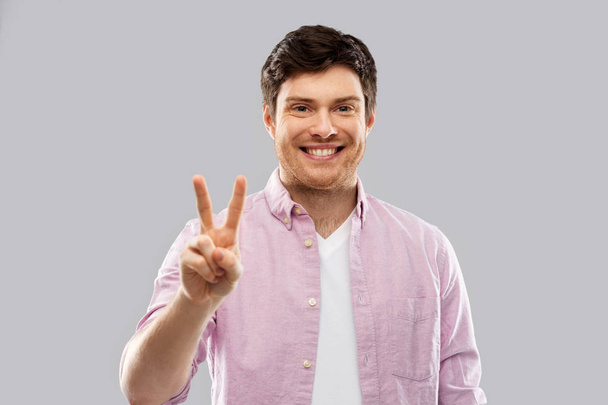young man showing two fingers or peace hand sign - Фото, зображення
