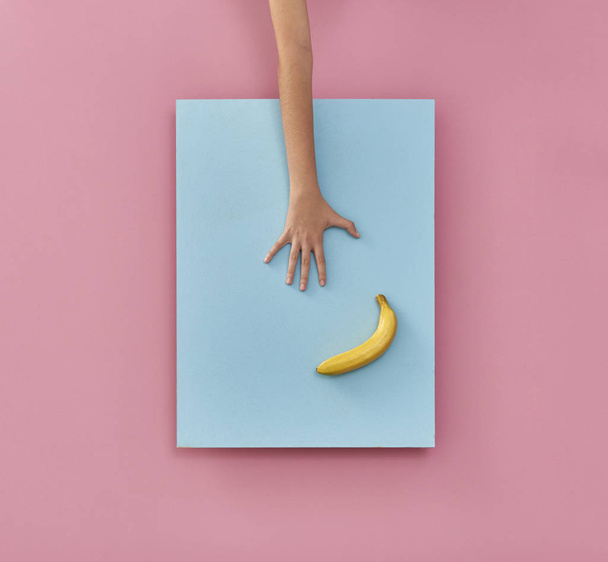 手と果物とピンクと青の背景 - 写真・画像