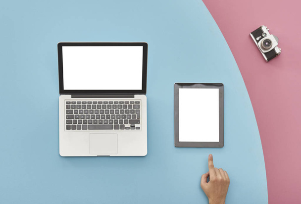 mano e tablet pc e laptop su sfondo a colori, vista dall'alto
 - Foto, immagini