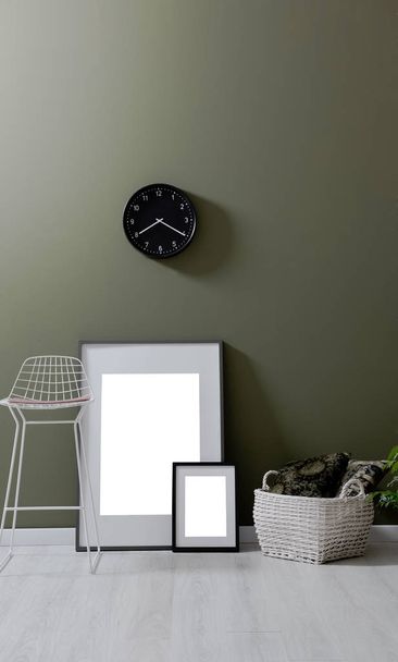 Зелена стіна, стілець стіл і стиль прикраси рами годинник
. - Фото, зображення