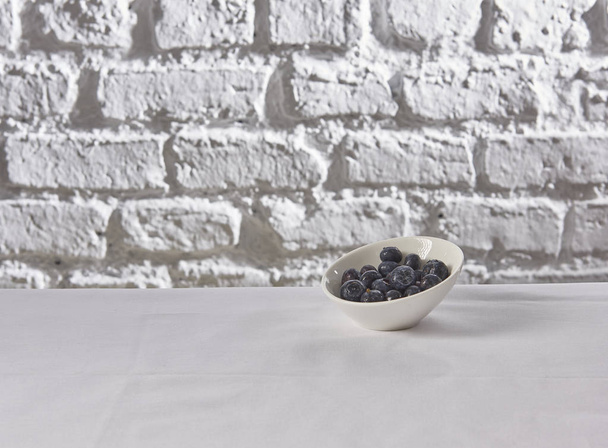  blueberries behind brick wall white background - Photo, Image