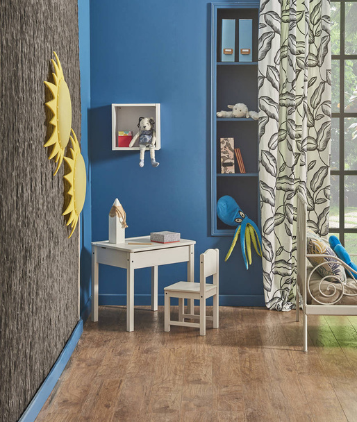 Estilo decorativo azul bebé y habitación infantil, vista al jardín, cama blanca y mesa de juego. - Foto, Imagen
