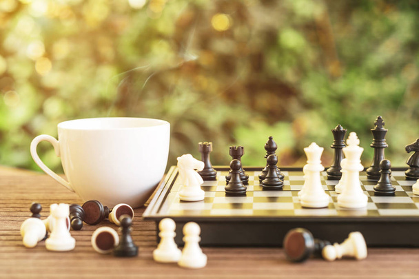 Satranç tahtası ile ahşap masa üzerinde kahve fincanı - Fotoğraf, Görsel