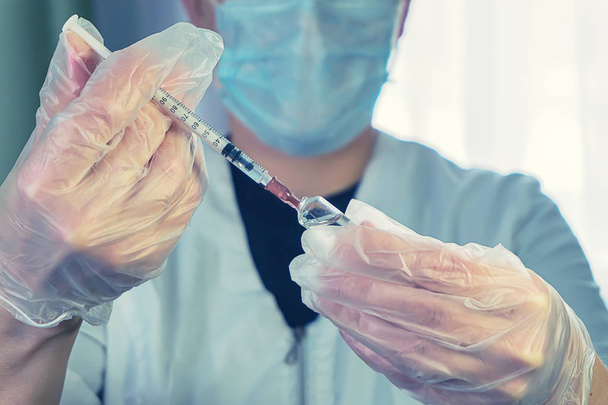 a woman in a white coat with a syringe in hand - Foto, Bild