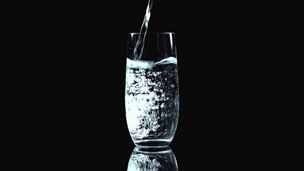 sesión de estudio de agua vertiendo en vidrio transparente aislado en negro
 - Metraje, vídeo
