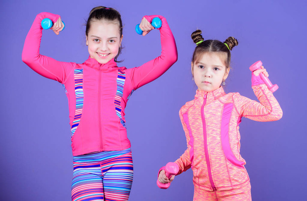 Active lifestyle. Sport and fitness for kids. Cute sisters doing gym fitness exercises with dumbbells. Little children developing physical fitness. Small girls enjoy fitness training with weights - Zdjęcie, obraz