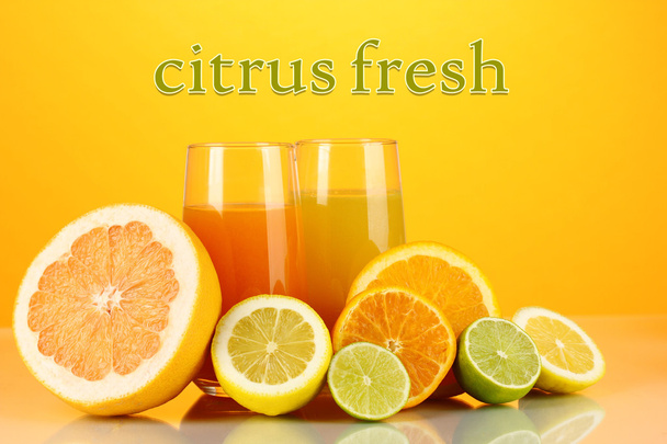 Lots ripe citrus with juices on orange background - Fotó, kép