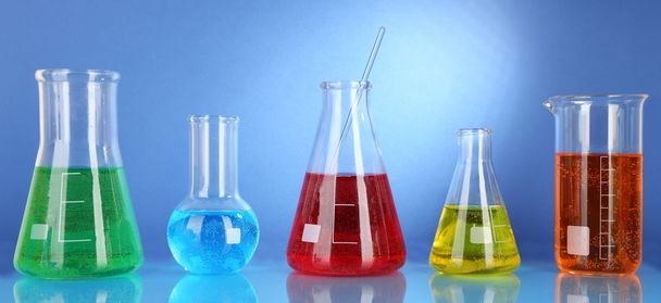 Test tubes with colorful liquids on blue background - Φωτογραφία, εικόνα