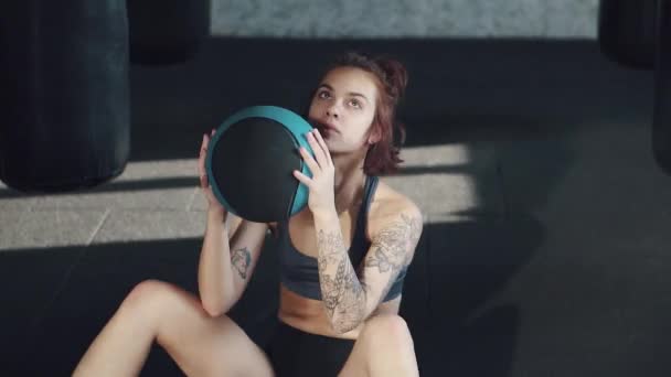 athlete doing exercise on the abdominal muscles in the gym. modern girl with a tattoo trains. - Filmagem, Vídeo