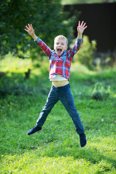 little boy joyfully jumping in the summer in the garden - Fotoğraf, Görsel