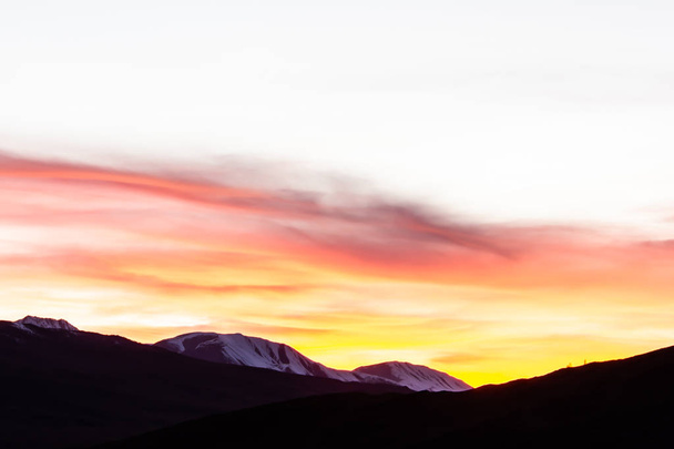 Golden stratus clouds above mountain silhouette. Sunset in mountain valley - Fotoğraf, Görsel