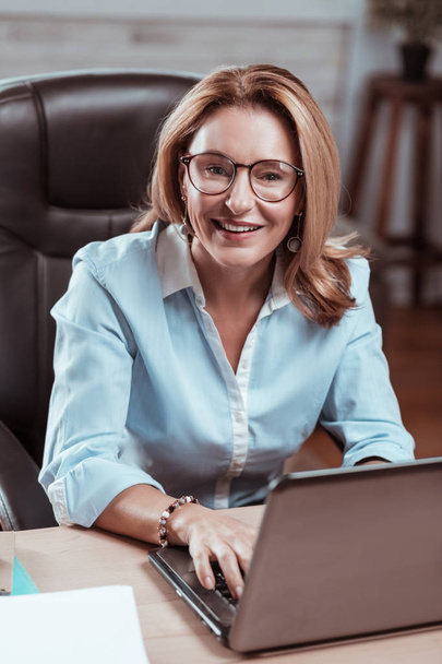Mature businesswoman smiling before starting new exciting project - Foto, afbeelding