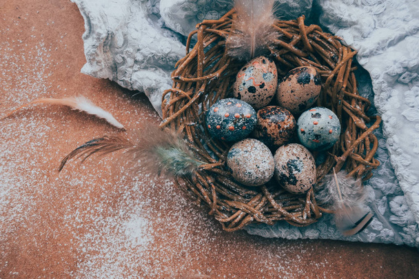 bright Easter background; Easter eggs basket and sprig flowers on blue table background - Foto, Bild