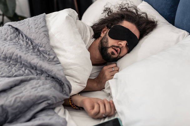 Nice brunette man sleeping in a mask - Foto, Imagem