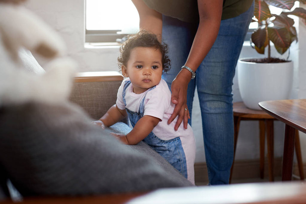 Mixed race baby girl cruising along sofa couch supported by mom, learning how to walk move growing  - Fotoğraf, Görsel