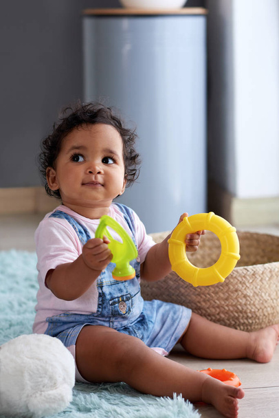 Young baby girl playing with toys at home and sitting on floor  - Foto, Imagem
