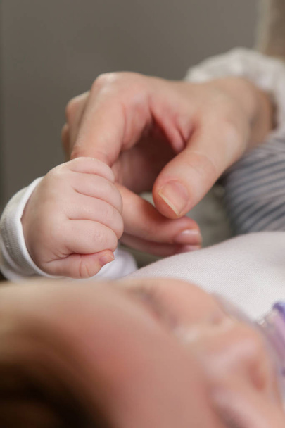 νεογέννητο μωρό που κρατά το δάχτυλο της μητέρας - Φωτογραφία, εικόνα