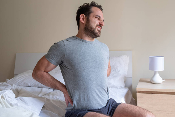 Man waking up in the morning and suffer for back pain - Photo, Image