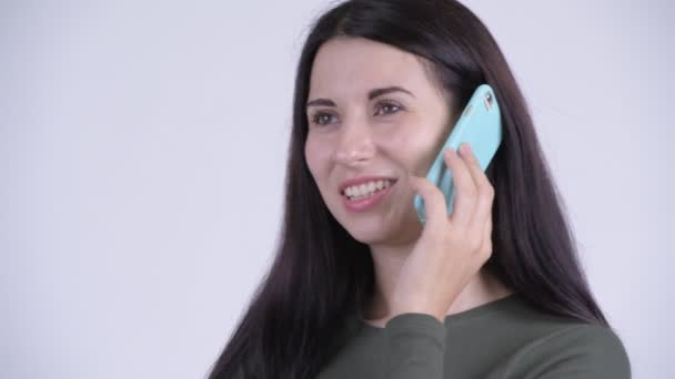 Face of happy young beautiful woman talking on the phone - Materiał filmowy, wideo