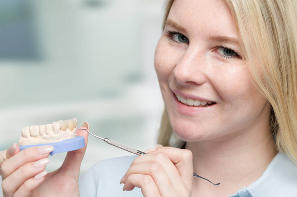 Νέοι οδοντοτεχνίτης λειτουργεί σε δόντι στέμμα στο οδοντοτεχνικό εργαστήριο - Φωτογραφία, εικόνα