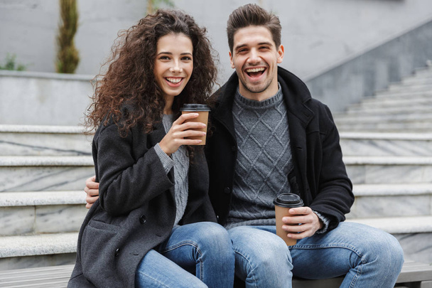 Image of caucasian couple man and woman 20s in warm clothes, dri - Foto, Imagem