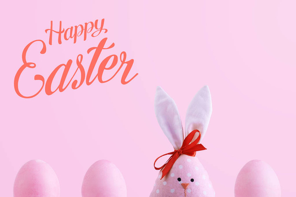 Handmade rabbit among Easter eggs, concept of celebration and fun. Text, happy easter. - Valokuva, kuva
