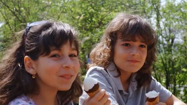 Chłopiec i dziewczynka jedzenie lodów w parku, 4k - Materiał filmowy, wideo