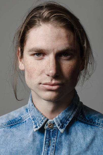 Portrait of a handsome long-haired man with freckles dressed in a denim shirt - Foto, afbeelding