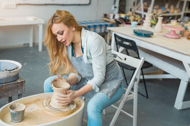 beautiful young girl makes a jug of clay with their own hands - Foto, Imagen
