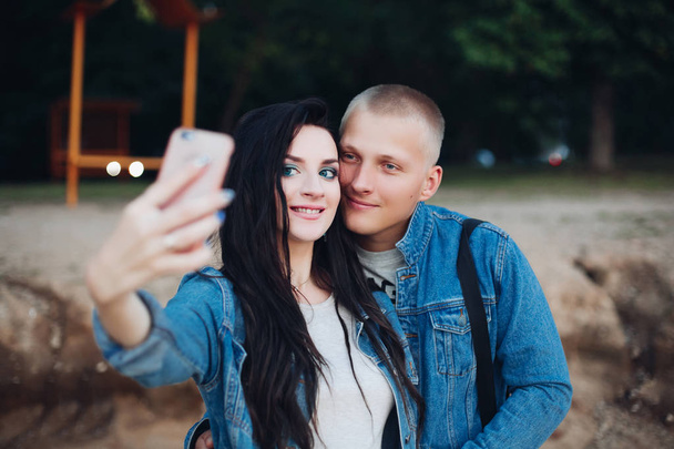 Schönes Paar spaziert durch Park und macht Selfie zusammen - Foto, Bild