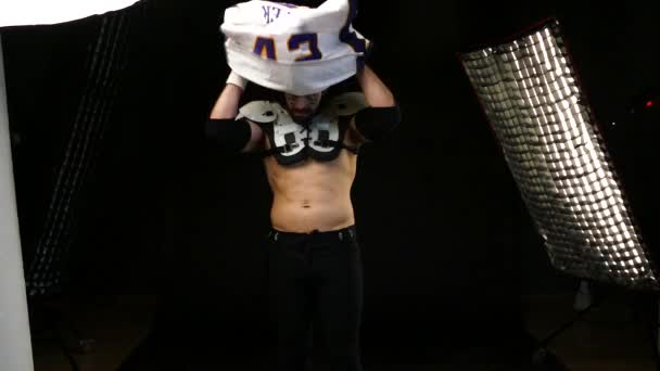 American Football Player wearing his sport dress on Black Background - Кадри, відео