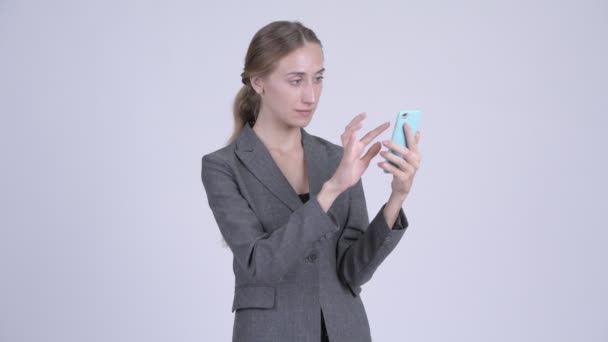 Happy young blonde businesswoman using phone and getting good news - Filmmaterial, Video