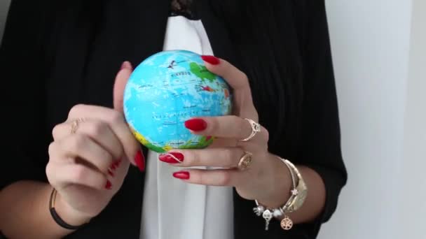 Female Hands Holds and rotates toy ball globe of the Earth. - Video