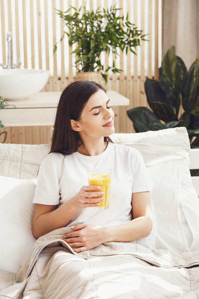 Woman Drinking Juice at the Bed - Valokuva, kuva