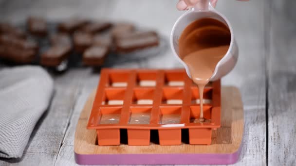 Pastelero llenando un molde de silicona con una mousse de chocolate. Hacer postre francés
. - Metraje, vídeo