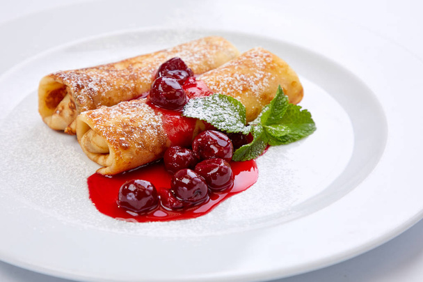 sweet pancakes with cherries on white plate, close-up  - Zdjęcie, obraz