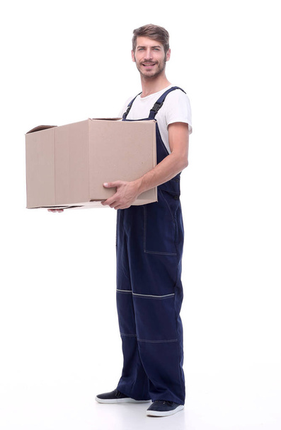 man in a jumpsuit holding a large box - Photo, image