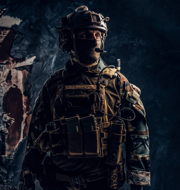 Particuliere beveiliging dienst aannemer in camouflage pak en helm met walkie-talkie. - Foto, afbeelding