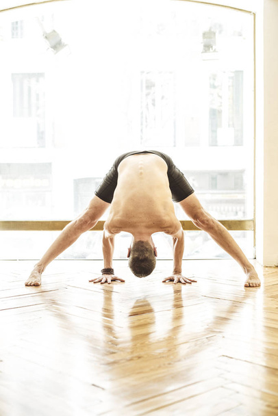 Muž, který dělat jógu na dřevěnou podlahu - Fotografie, Obrázek