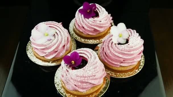 紫と白の花で飾られたピンクのマシュマロ クッキーの小さなグループにズームインします。 - 映像、動画