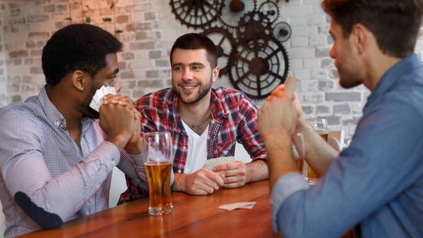 Migliori amici che giocano a carte, avendo il riposo in bar
 - Foto, immagini