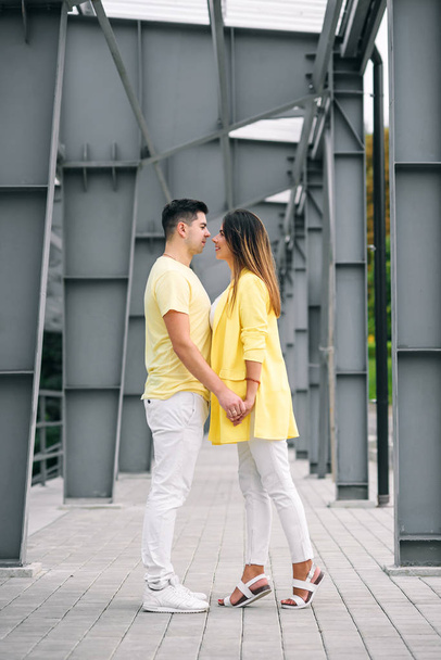Lovely young couple in bright clothes holding hands - Fotó, kép