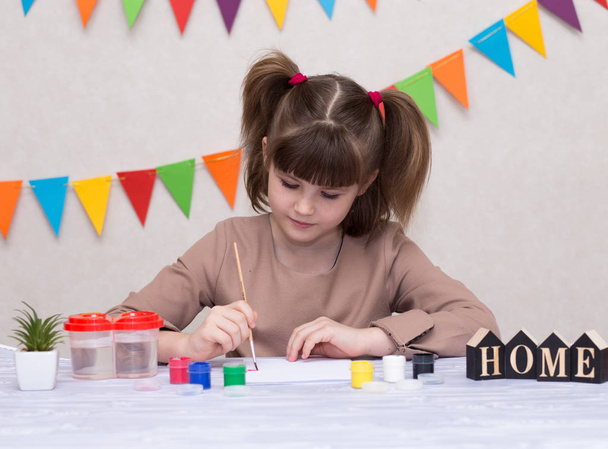 Child making homemade greeting card. Little girl paints heart on homemade greeting card as gift for Mother Day. Traditional play concept. Arts concept - Photo, Image