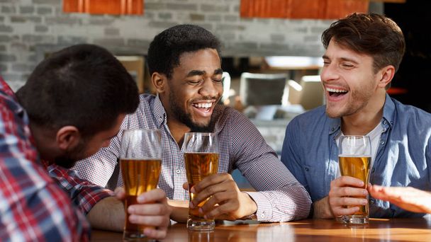 Reunión de amigos. Hombres bebiendo cerveza y hablando en el bar
 - Foto, imagen