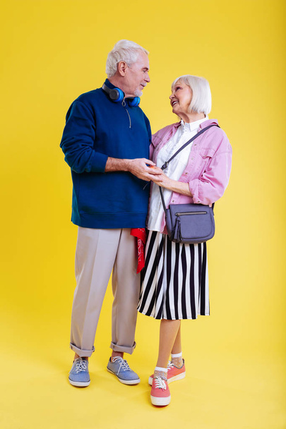 Modern retired couple wearing sneakers looking at each other - Fotó, kép