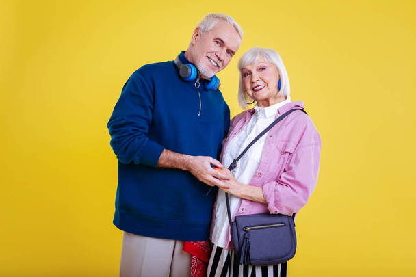 Retired couple wearing modern stylish clothes smiling broadly - Фото, изображение