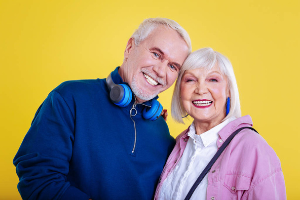 Bearded blue-eyed retired man standing near his lovely lady - Foto, imagen