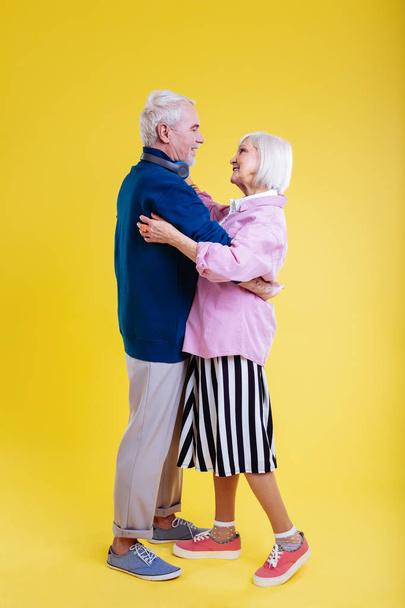 Couple of pensioners wearing stylish clothes dancing together - Fotografie, Obrázek