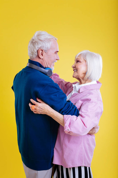Happy elderly lady dancing with her strong supportive husband - Foto, Imagen